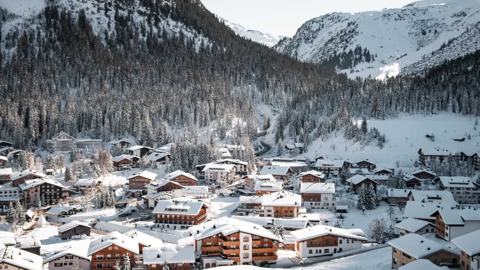 Why Do So Many Groups Search for Apartments in Austria for Friends and Teams Directly on the Slope? Snow-covered Austrian alpine village with chalets beside the piste