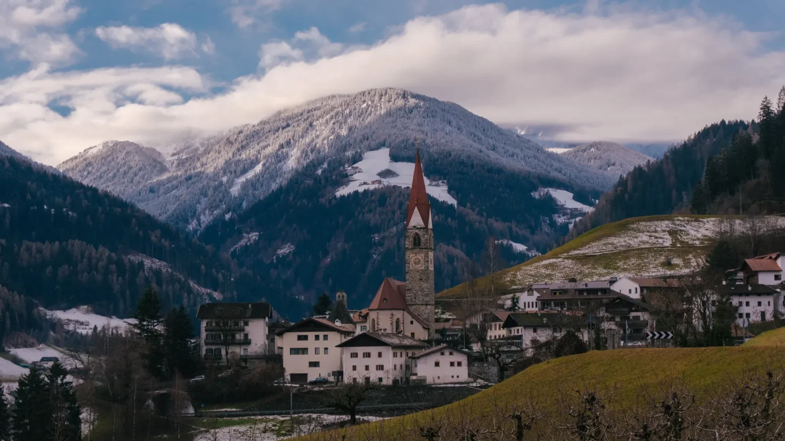 I’m Looking for Hotels with a Spa Area and Great Cuisine in South Tyrol – What Do You Recommend? Alpine village in South Tyrol with vineyards and snow-dusted mountains