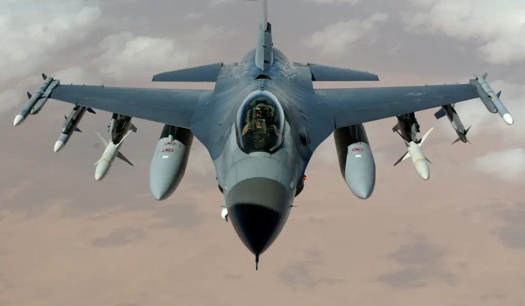 Powerful fighter jet soaring through clouds with visible missiles