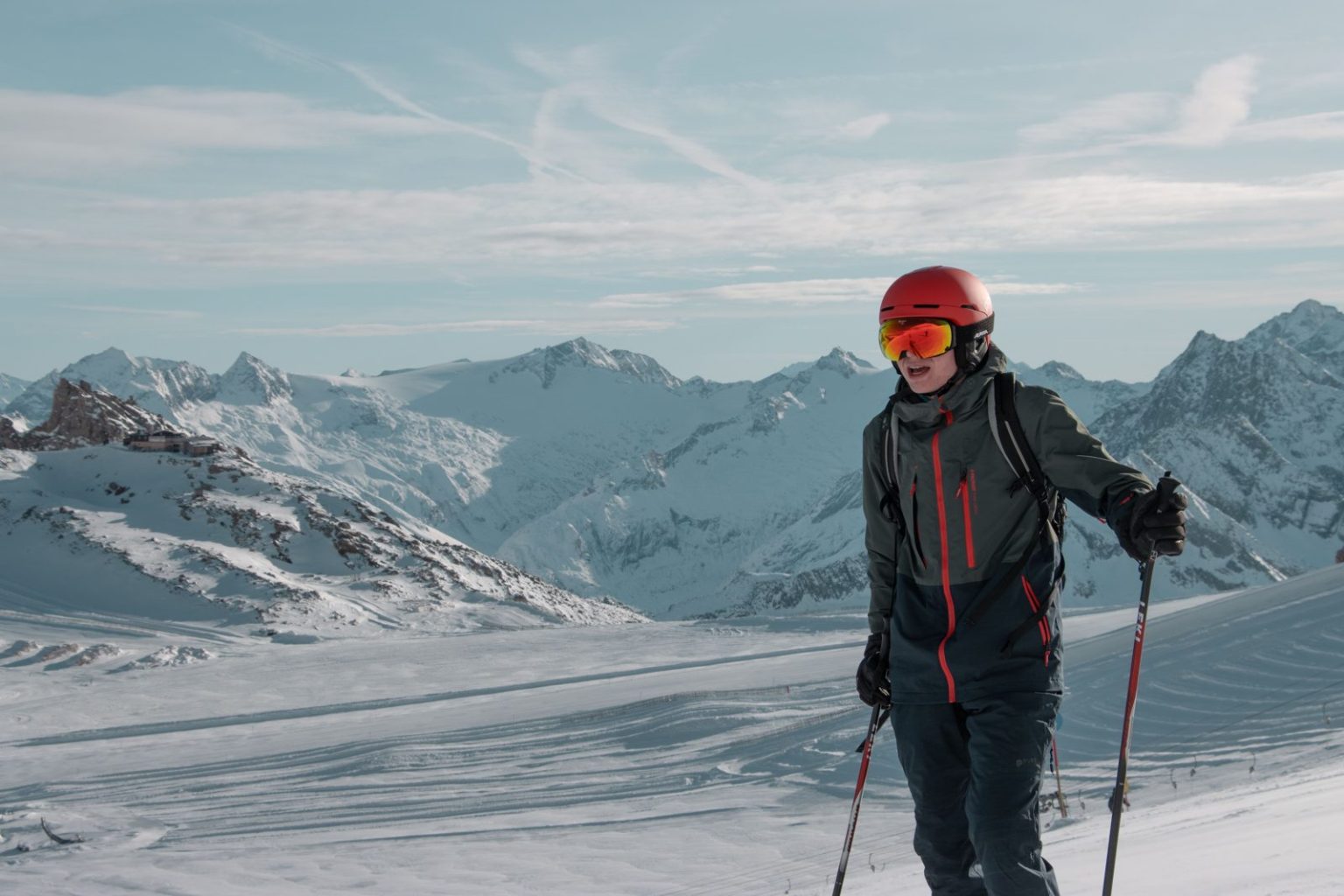 Skier on a snowy alpine slope under clear skies, illustrating autumn glacier skiing in Austria